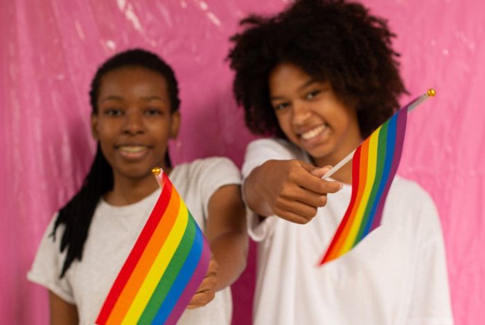 Young people waving rainbow pride flags